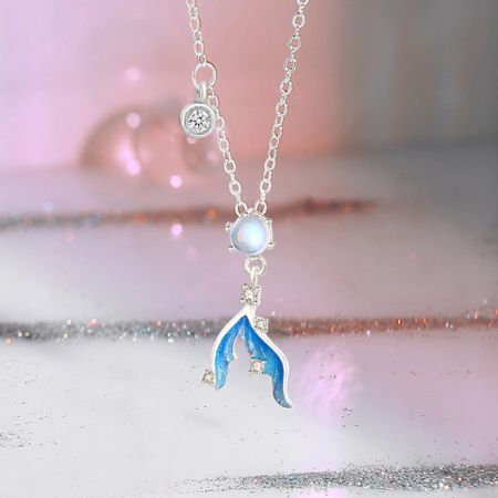 Close-up of the mermaid tail pendant showing blue enamel details and clear gems.