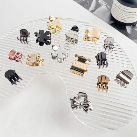 Mini clips de cabello pequeños de aleación metálica - Una colección diversa de mini clips de cabello de aleación metálica en varias formas como flores y lazos, y colores que incluyen dorado, plateado y negro.