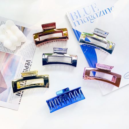 Clips de pelo metálicos huecos cuadrados en forma de plátano. - Una colección de seis clips de pelo metálicos huecos cuadrados en varios colores metálicos, exhibidos sobre un fondo blanco limpio.