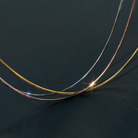 Primo piano delle catene a serpente in argento 925 con finiture in oro, argento e oro rosa.