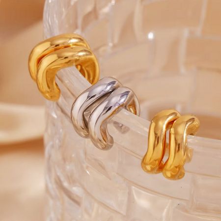 Classic Style Geometric 14mm Cartilage Ear Cuff Earrings Stainless Steel (5 pairs) - A set of three classic stainless steel cartilage ear cuff earrings in gold and silver finishes, displayed on a glass object.