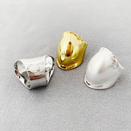 Close-up product shot of the drum-shaped rings in gold and silver.