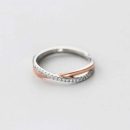 Detaillierte Ansicht des Möbius-Rings aus Mischmetall, der das filigrane Design und die funkelnden Zirkonia betont.
