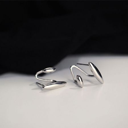 Un paio di orecchini a cerchio moderni in argento sterling 925 con un design astratto.