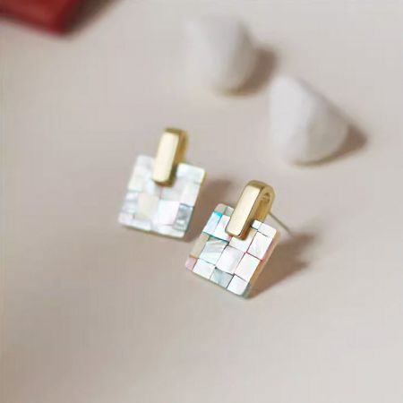 目立つ金のアクセントがある多色モザイクイヤリングの詳細ビュー。