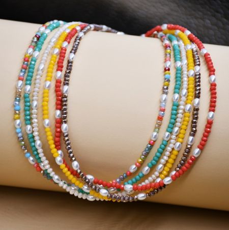 Nahaufnahme der mehrfarbigen Perlenkette und des passenden Armbands, die auf einer Schneiderpuppe präsentiert werden.