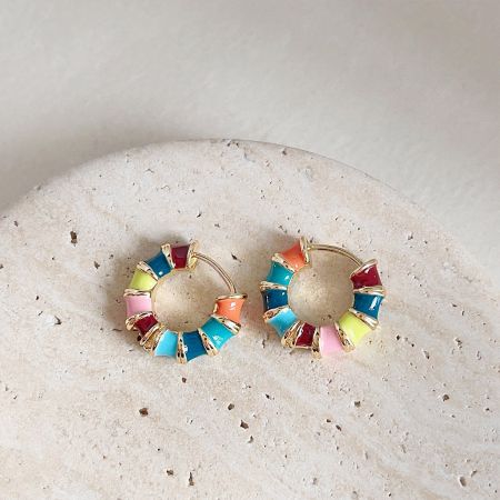 14k Gold Plated Rainbow Multi-Color Enamel Bamboo Hoop Earrings - A pair of 14k gold plated bamboo hoop earrings with vibrant rainbow multi-color enamel, displayed on a decorative stone.
