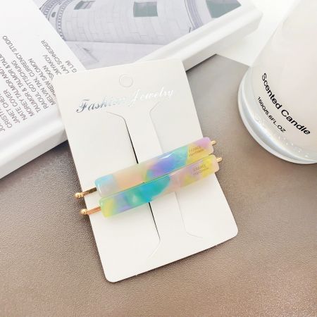 A vibrant, multicolored acetate hair clip displayed as a statement fashion accessory.