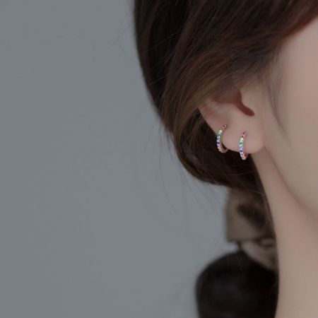 Model showcasing the vibrant multicolored rhinestone hoop earrings.