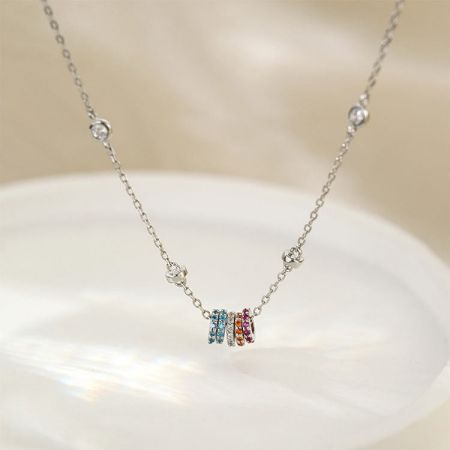 Collar de Charms de Círculos de Zirconia Arcoíris Coloridos de Plata 925 - Un primer plano del collar de plata esterlina 925 con un colgante de cinco charms de zirconia arcoíris en un fondo blanco.