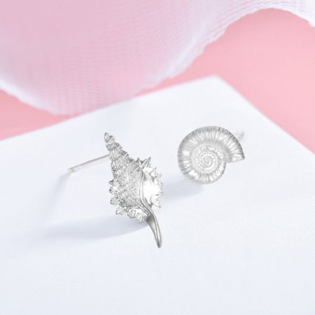 925 Sterling Zilveren Asymmetrische Schelp Conch Stud Oorbellen (5 Paar) - Een set van vijf paar 925 sterling zilveren asymmetrische schelp en conch stud oorbellen, weergegeven op een roze en witte achtergrond.