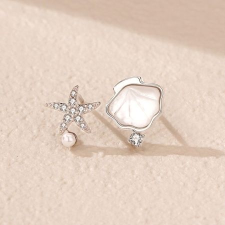 Primo piano di un orecchino a forma di stella marina in argento sterling con un accento di perla.