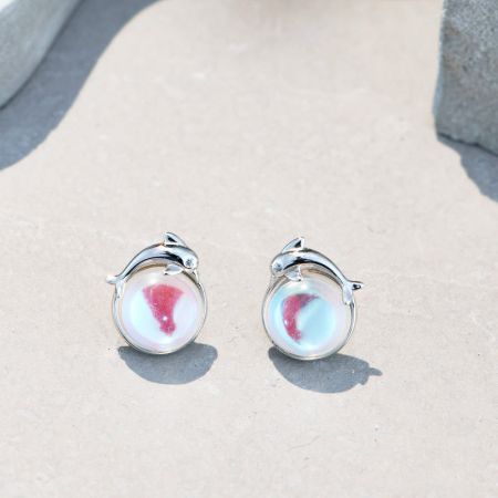 Orecchini a bottone in argento sterling 925 con pietra di luna a forma di delfino (set di 5 paia) - Un primo piano degli orecchini a bottone in argento sterling 925 con pietra di luna a forma di delfino, che mette in mostra il dettagliato montaggio in argento a forma di delfino e la pietra di luna iridescente.
