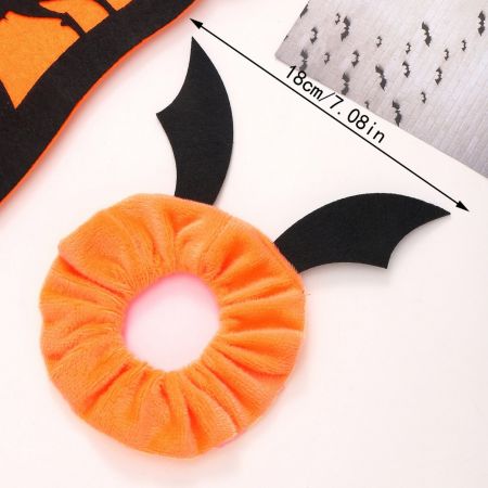 Um scrunchie laranja brilhante com detalhes de asas de morcego, perfeito para o Halloween.