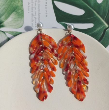 Una variación de los pendientes acrílicos en forma de hoja en tonos cálidos, con un hermoso degradado de naranja a rojo.