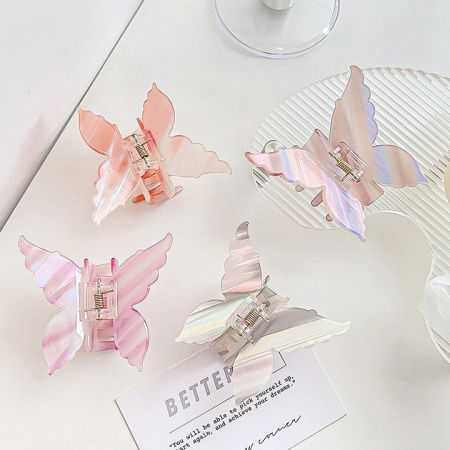 Four pastel-colored butterfly hair clips in shades of pink, blue, green, and yellow.