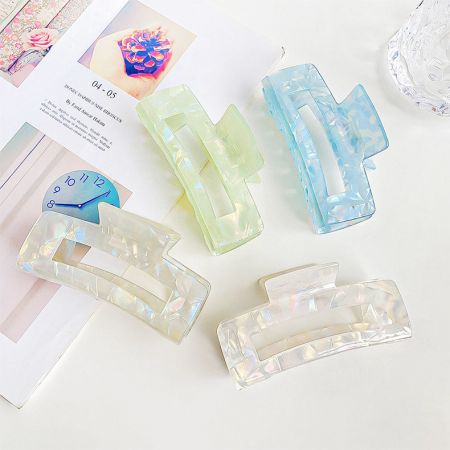 白い背景に対して、パステルカラーのアセテートヘアクリップ4つのセット。