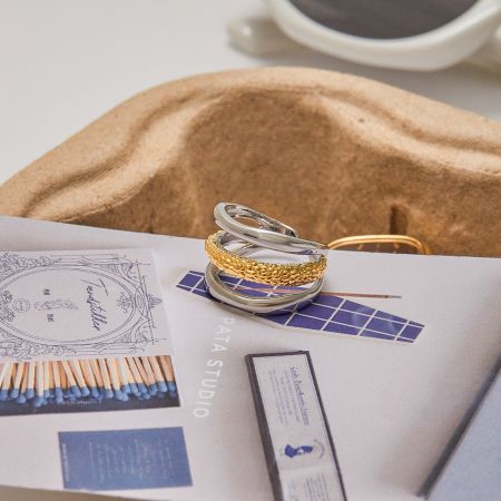 Een collectie van twee-kleurige minimalistische ringen uit de groothandelsset, elegant tentoongesteld.