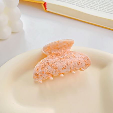 Unique peach-colored insect-shaped hair clip with intricate details.