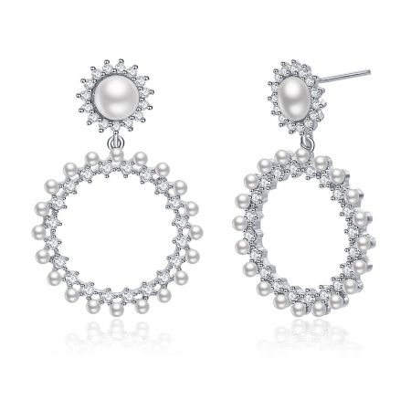 Gros plan détaillé des boucles d'oreilles Show Love, mettant en valeur l'agencement complexe de perles et de pierres claires.