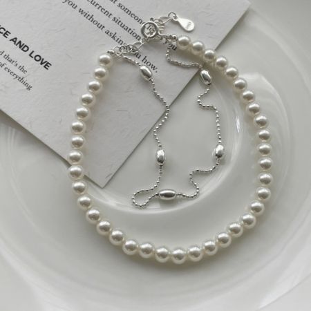 925 Sterling Zilveren Parel Dubbele Ketting Armband - Een prachtig vervaardigde 925 Sterling Zilveren Parel Dubbele Ketting Armband, die zijn delicate ontwerp en glanzende parels tegen een schone achtergrond toont.