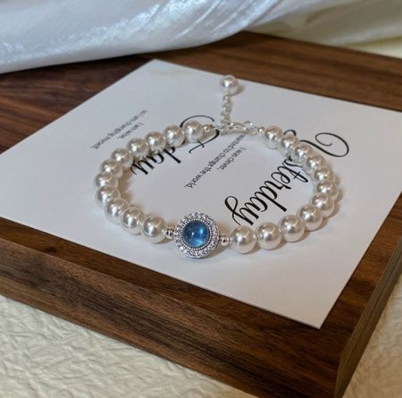 925 Sterling Zilveren Parel Blauwe Armband - Elegante 925 sterling zilveren parelarmband met een prachtige centrale blauwe edelsteen en sprankelende cubic zirconia accenten.