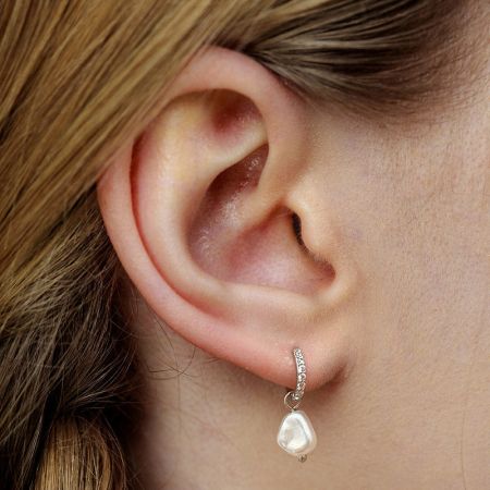 Model wearing the baroque pearl and zirconia drop earring to showcase its elegant drape and style.