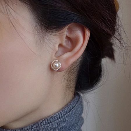 Modello che indossa gli orecchini a perno in perla a conchiglia vuota in stile francese per mostrare la loro dimensione e aspetto.