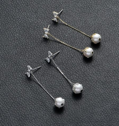 Detailed view of the pearl and cubic zirconia accents on the dangle earrings.