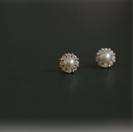 Vista dettagliata degli orecchini a perla in argento sterling 925 con zirconi cubici, che mette in evidenza l'aureola brillante di zirconi cubici che circonda la perla.