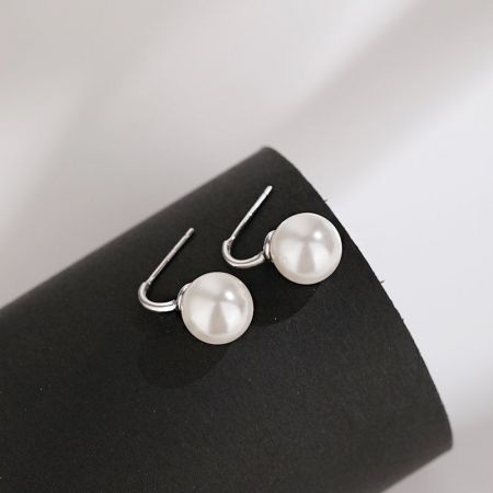 Primo piano dettagliato dell'orecchino C-hook con una perla singola in argento sterling 925 con finitura argentata.