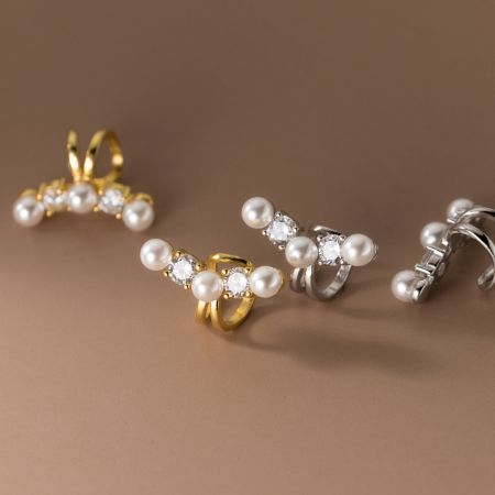Collezione di orecchini a cuffia con perle e pietre preziose disponibili sia in argento sterling che in finiture dorate.