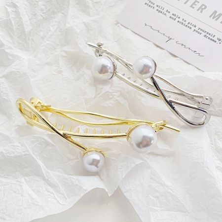 Gold and silver versions of the twisted double pearl hair clips shown side-by-side.