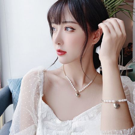 Modelo usando el elegante collar de perlas con colgante de corazón de San Valentín y el conjunto de pulsera.