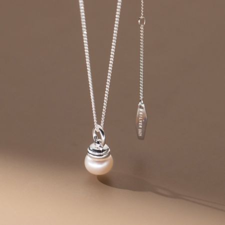 Detailed close-up of the sterling silver pearl necklace, showing the 'SILVER 925' stamp for authenticity.