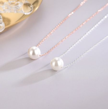 Collar de perlas de concha de plata esterlina 925 - Un par de collares de perlas de concha de plata esterlina 925, uno chapado en oro rosa y el otro en plata, que muestran el diseño elegante y las perlas brillantes.