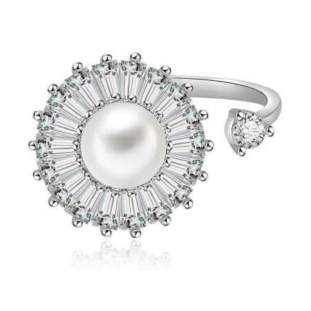 Spinning Pearl Ring - A close-up of the Spinning Pearl Ring, featuring a large central pearl surrounded by a halo of baguette-cut diamonds on a rhodium-plated band.
