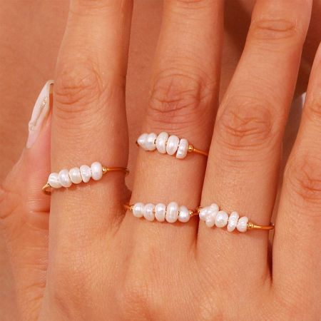Daily Wear Vrouwen Roestvrijstalen Barokke Zoetwaterparel Ring Set van 5 - De hand van een model die de elegante Daily Wear Vrouwen Roestvrijstalen Barokke Zoetwaterparel Ring Set toont, met de nadruk op hun unieke ontwerp en geschiktheid voor dagelijkse mode.