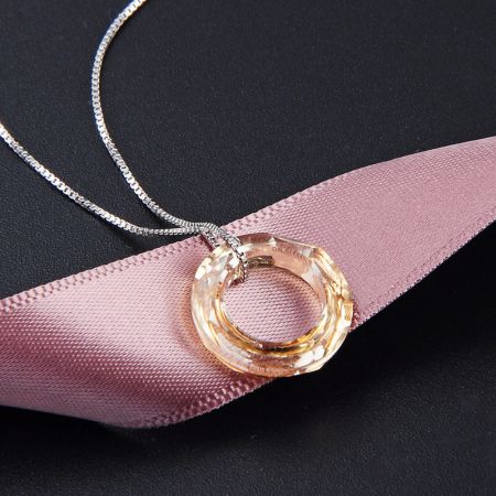 Primo piano del pendente a cerchio di cristallo rosa su una collana in argento sterling 925.
