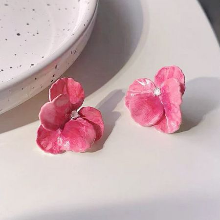 透明なジルコンの中心を持つピンクの花イヤリングの上からのビュー。