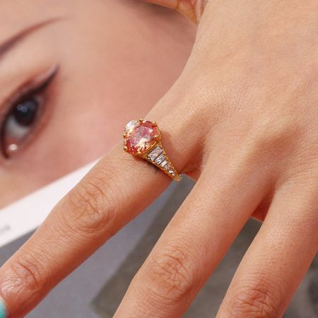 Anello regolabile in acciaio inossidabile con un grande zirconia ovale rosa e pietre di accento bianche.
