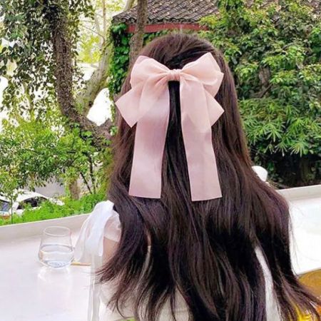 분홍색 새틴 리본 헤어 클립의 상세 제품 사진.