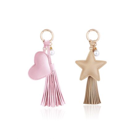 Decorative keychains featuring pink heart and gold star charms with colorful tassels.