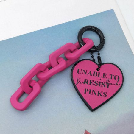 Porte-clés en cuir PU rose vibrant en forme de cœur avec un message ludique 'IMPOSSIBLE DE RÉSISTER AUX ROSES'.