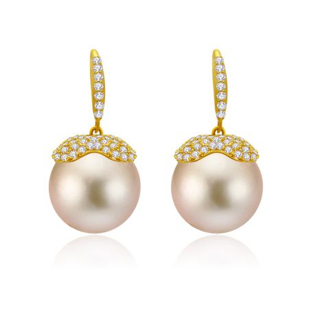 Boucles d'oreilles pendantes élégantes avec de grandes perles roses et des montures en or incrustées de diamants.