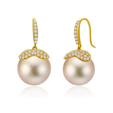 Vue détaillée des boucles d'oreilles pendantes en perles roses mettant en valeur les capuchons en or et les crochets avec des accents en diamant.