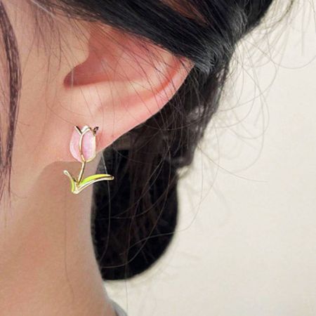 Profil latéral d'un modèle portant la délicate boucle d'oreille en tulipe rose.