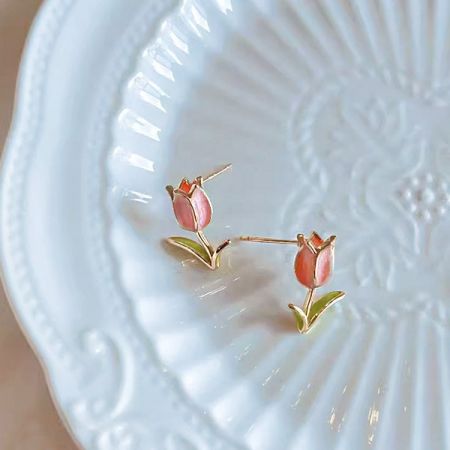 Vue de dessus de la paire de boucles d'oreilles en or présentant le design de la tulipe rose.