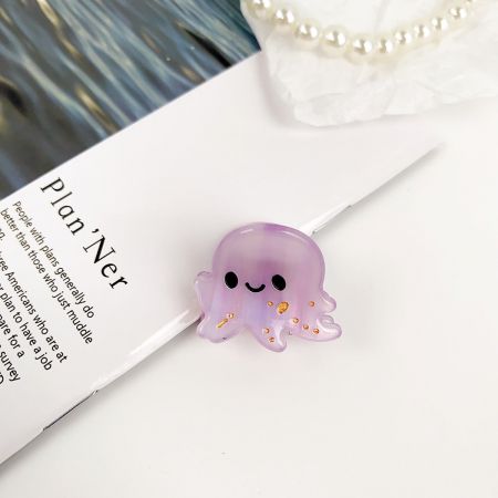笑顔の顔を持つ愛らしい紫のタコのヘアクリップ。