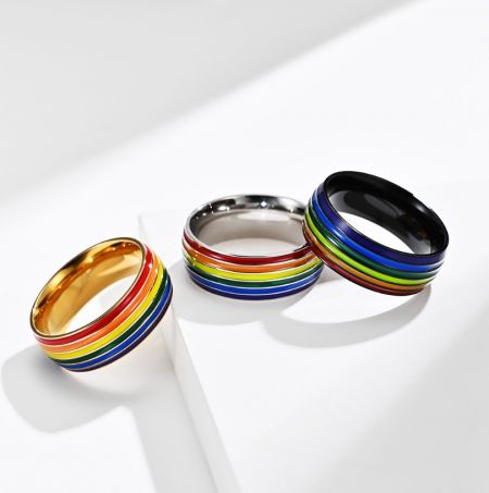 Regenboog Emaille RVS Ring - Drie Regenboog Emaille RVS Ringen naast elkaar, die de beschikbare plating opties tonen: goud, zilver en zwart.